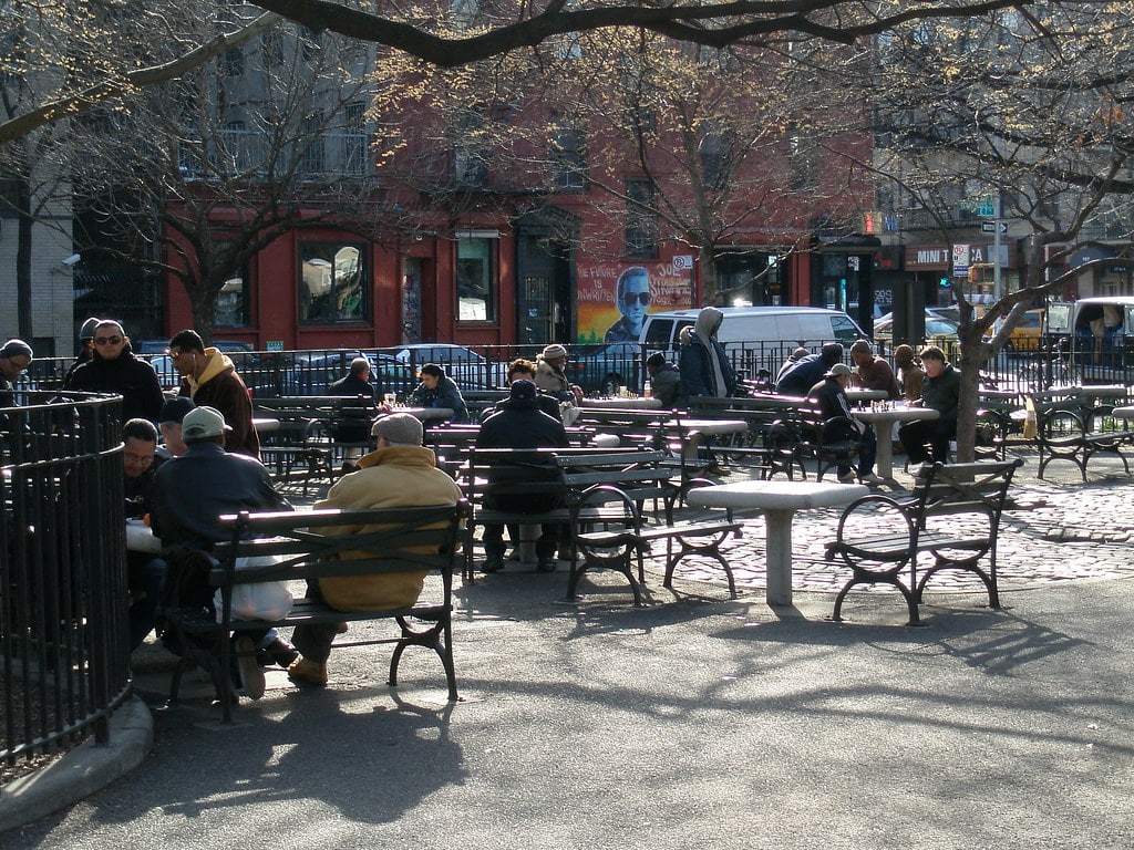 Tompkins Square Park, gens assis à des tables pour jouer aux échecs.