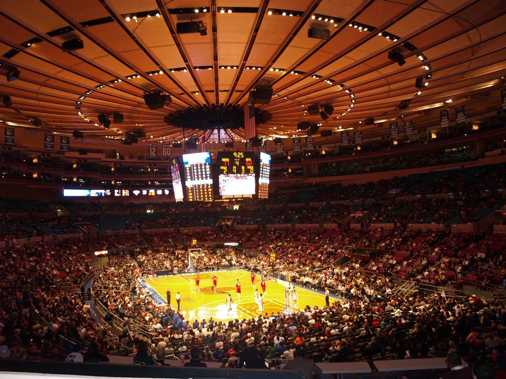 Match de basketball dans une arène bondée.