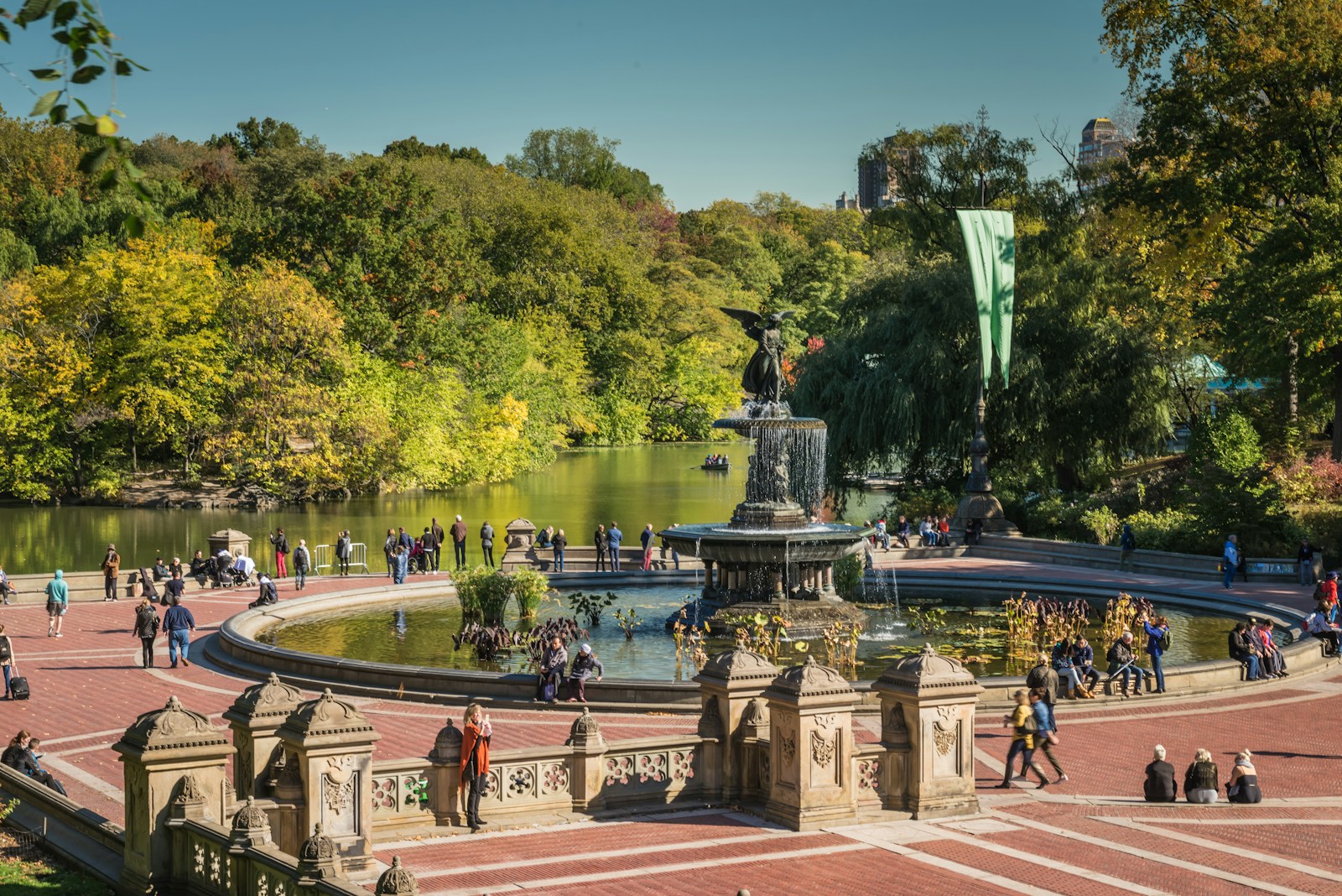 Photo by Richard Hedrick a group of people standing around a fountain in a park