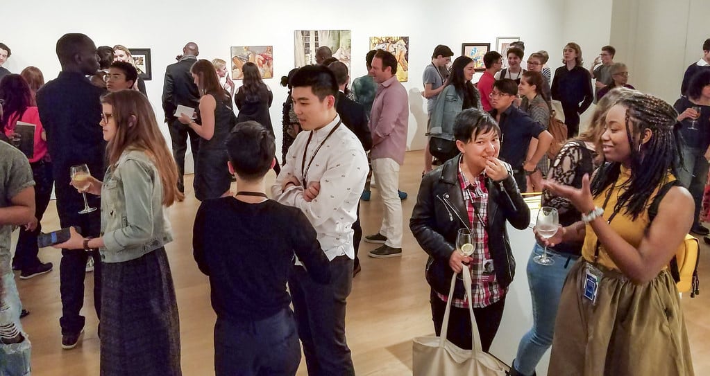Visiteurs divers lors d&#039;un vernissage dans une galerie d&#039;art.