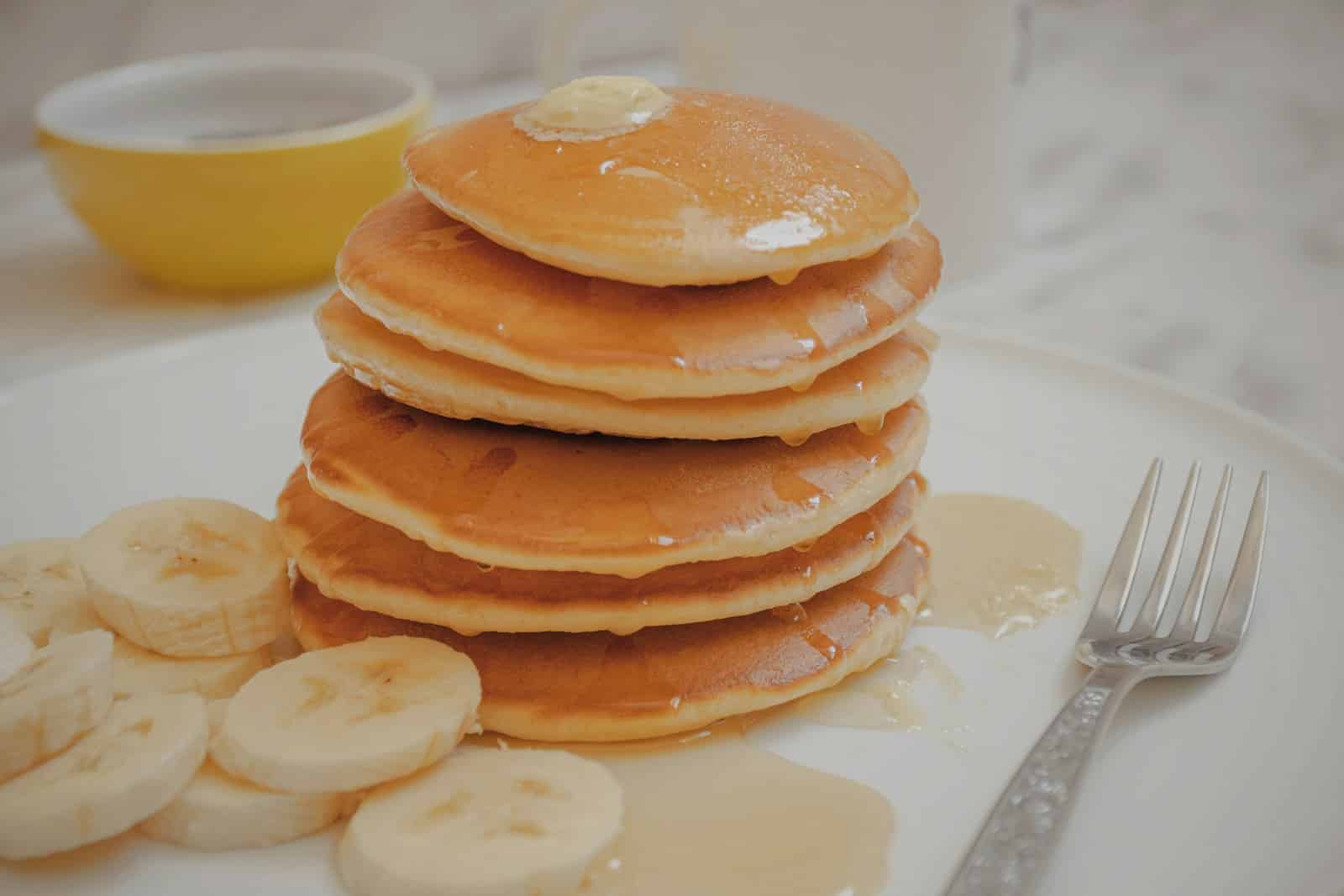 Pile de pancakes au sirop et bananes.